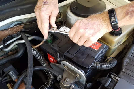 man fixing car battery